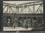 Die Trümmer der alten gesprengen Brücke im Stellgerüst der neuen Brücke